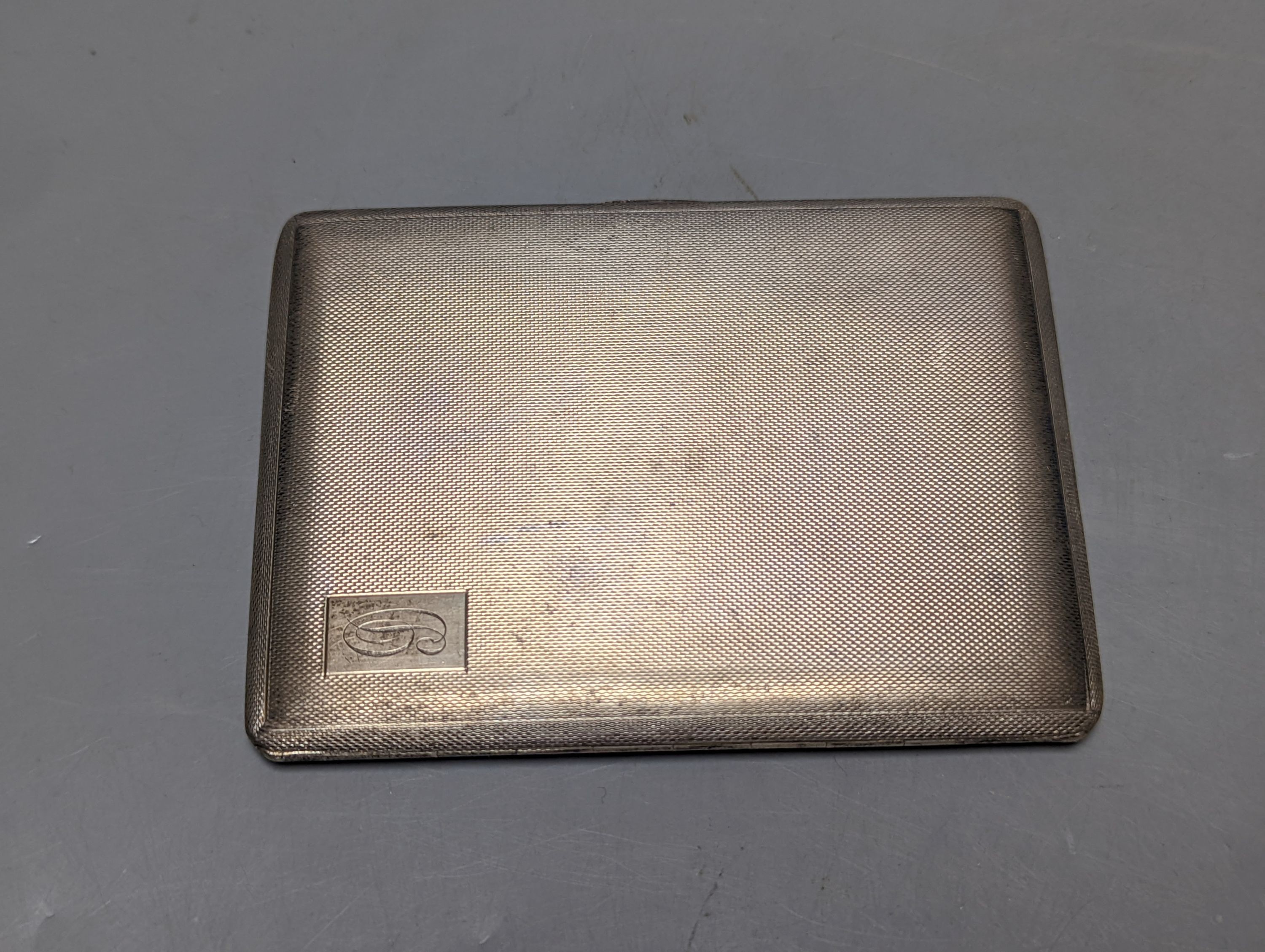A George V engine turned silver cigarette case, 11.3cm, together with an 800 standard white metal mounted cigarette box.